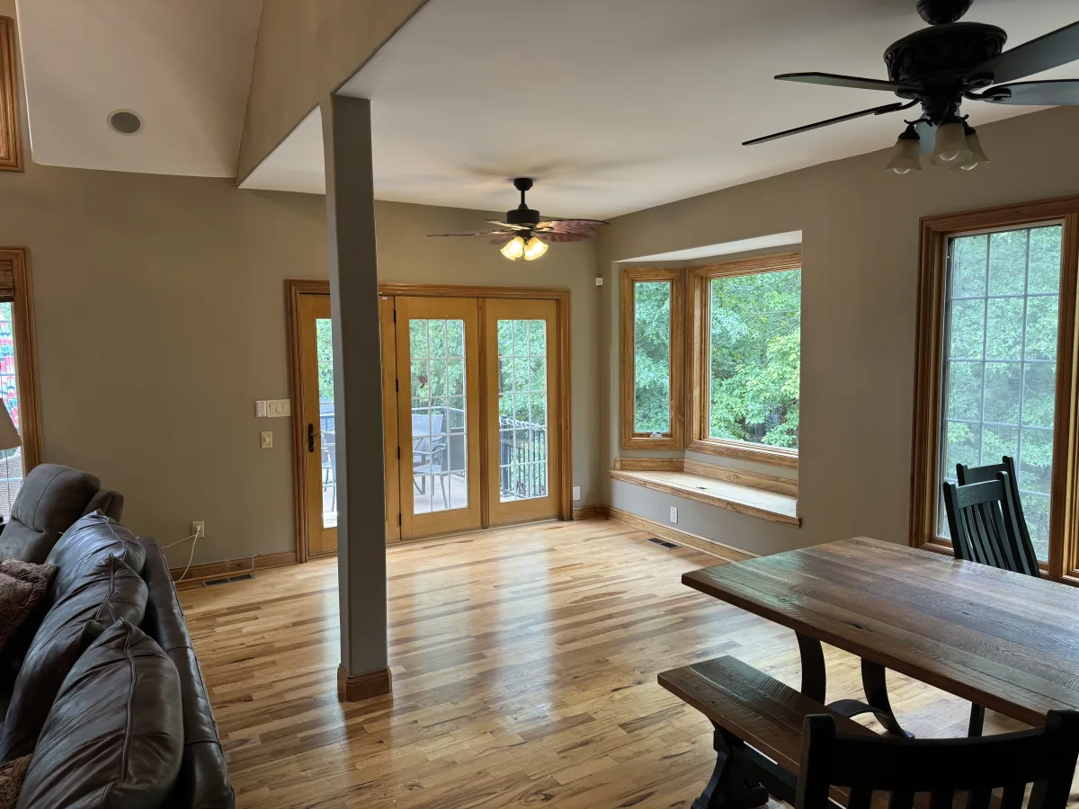 Columbus 2 Story Addition: Bright living space with new hardwood floors, bay window, wood-trimmed French doors. After remodeling.