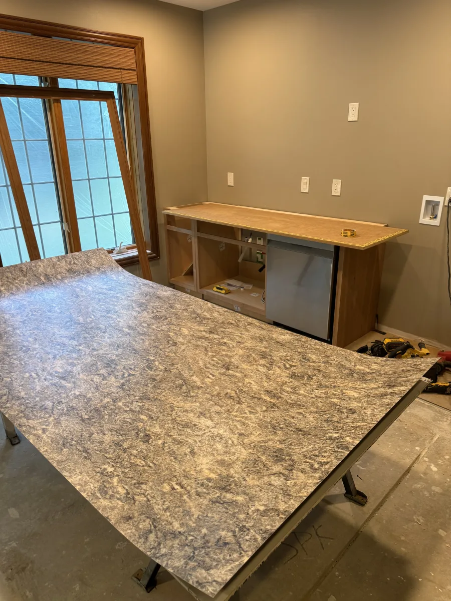 Columbus 2-story addition: In-progress utility room with gray laminate countertop material, unfinished cabinets, and mini-fridge.