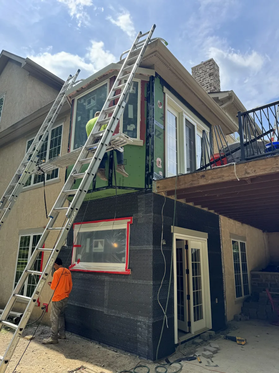 Columbus 2 story addition in progress with new Andersen windows, black sheathing, and stucco siding. Exterior home remodeling.