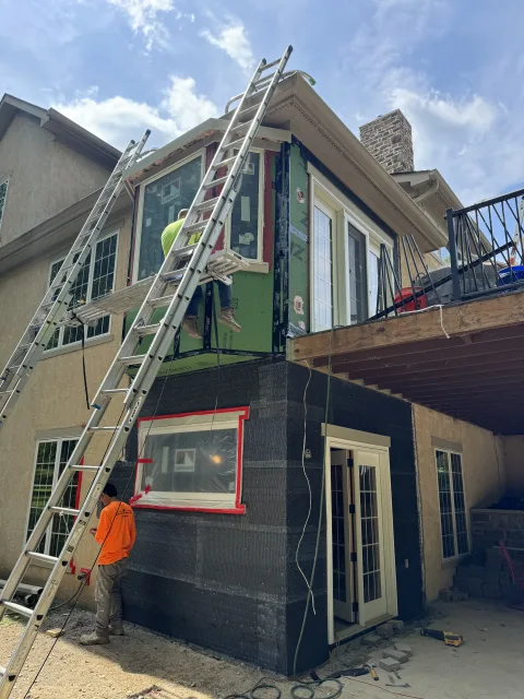 Columbus 2 story addition in progress with new Andersen windows, black sheathing, and stucco siding. Exterior home remodeling.