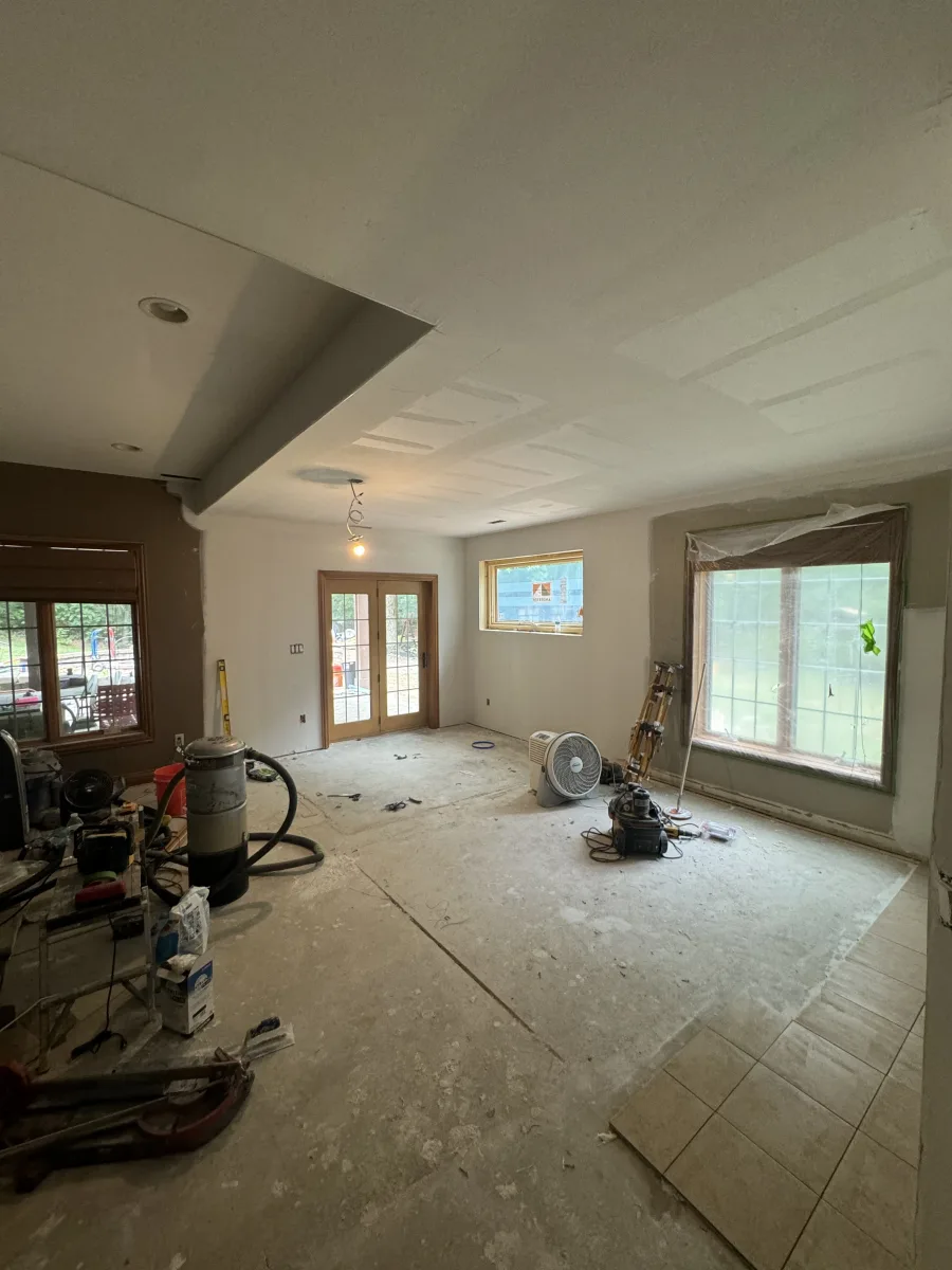 Columbus home remodeling: In-progress 2 story addition interior with bare floors, primed walls, new windows, and construction tools.