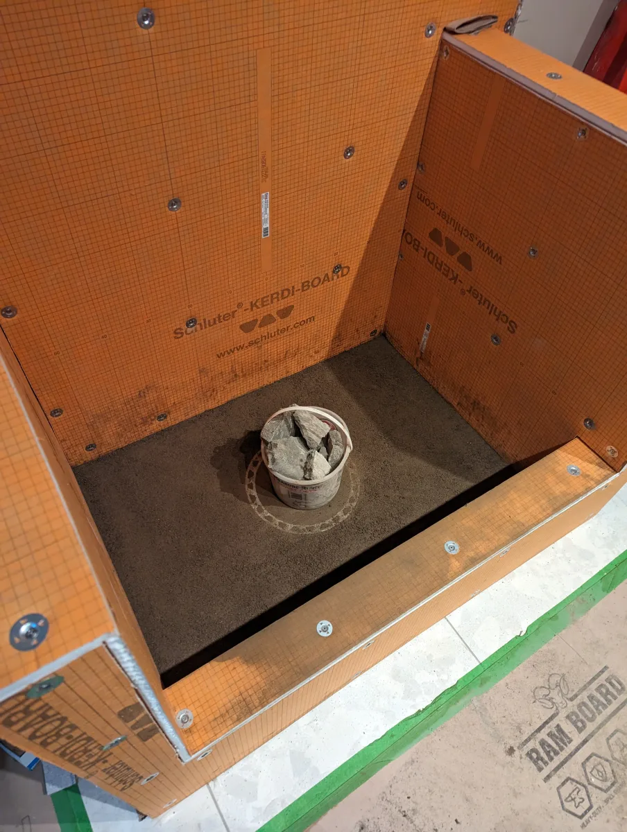 Columbus dog bathing station framing with orange Schluter Kerdi-Board panels, screws, and sloped mortar base for custom bathroom remodeling.