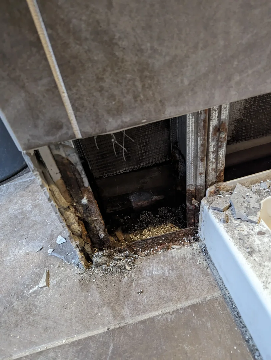 Severe water damage & corrosion on commercial shower framing with exposed tiles during Columbus bathroom renovation.