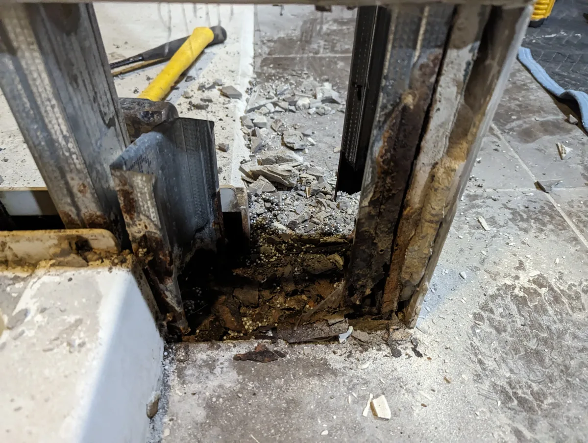 Rusted metal framing, water damage, and demolition debris during a Columbus commercial shower renovation.