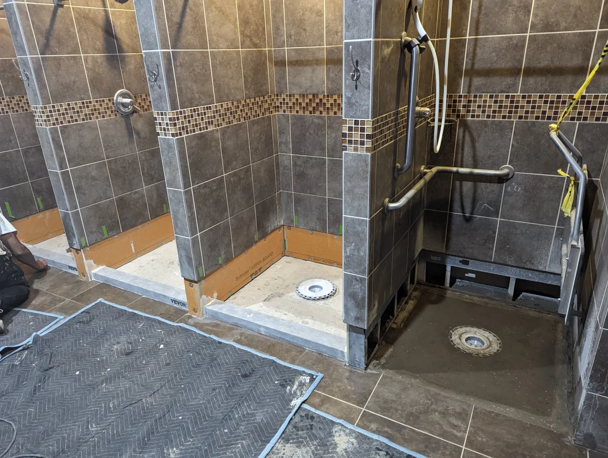 Columbus commercial shower renovation in progress with dark gray tile, mosaic accents, Kerdi-Board waterproofing, accessible shower.
