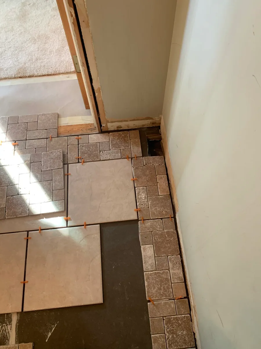 Columbus master bathroom floor tile. Light large-format and textured mosaic tiles installed with spacers during remodeling.