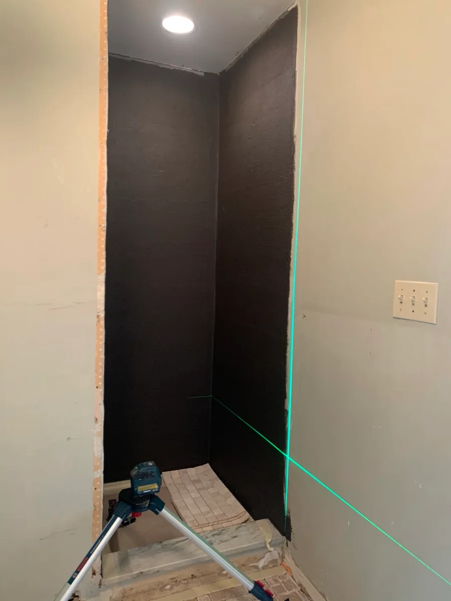 Columbus master bathroom shower remodeling. Waterproofed walls, laser level, and floor tile prep for precise installation.