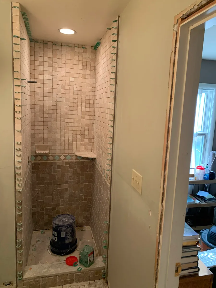 Columbus master bathroom remodeling: shower tile installation in progress with natural stone-look tiles & custom niche.