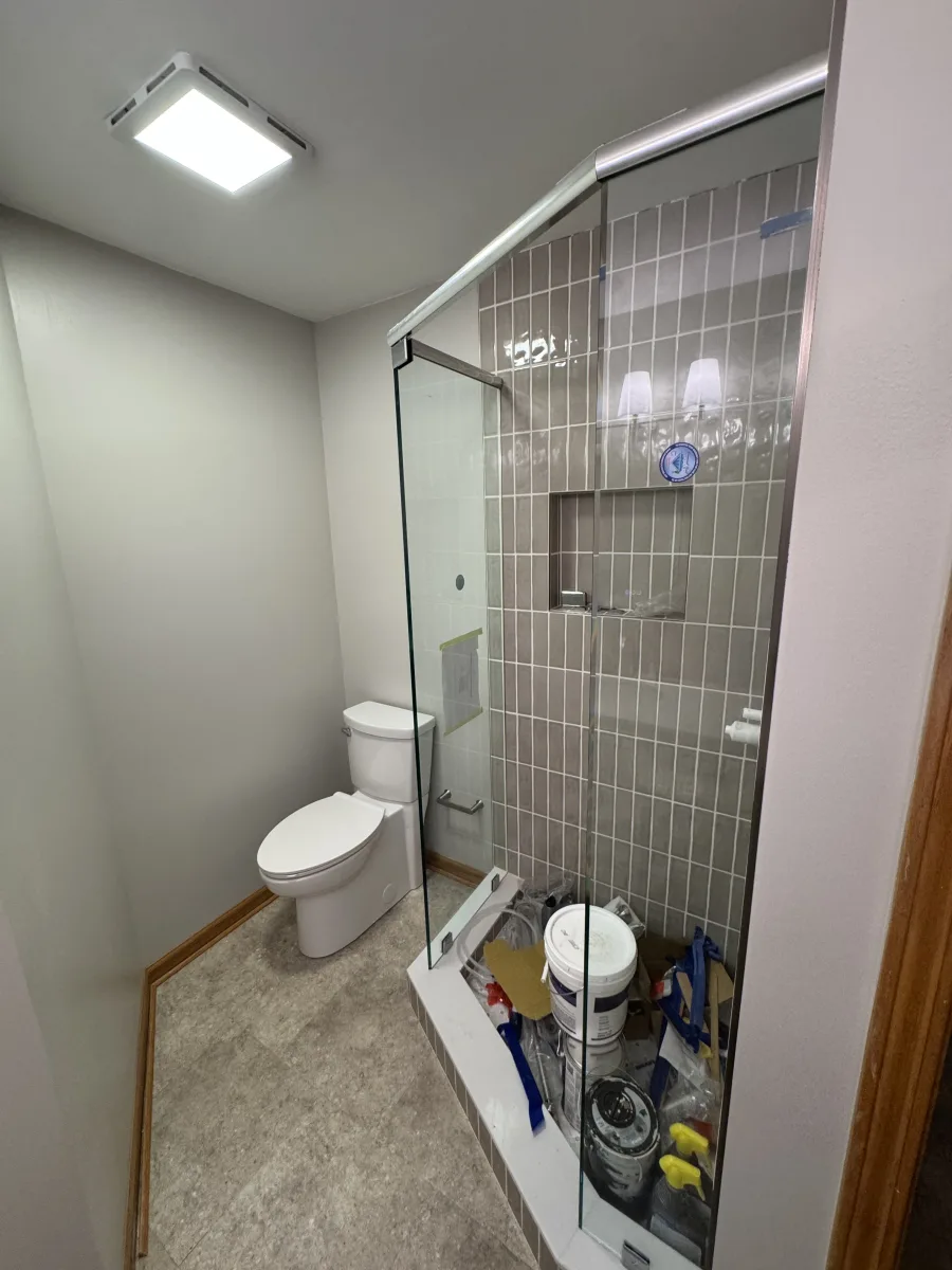 Columbus modern bathroom transformation with new white toilet, gray subway shower tiles, and sleek glass enclosure.