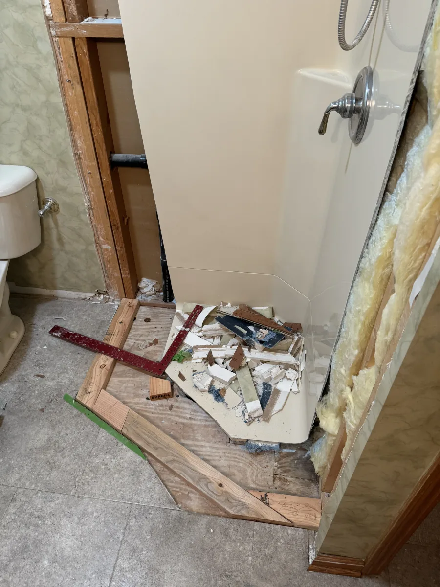 Columbus bathroom remodel in progress, showing shower demolition, exposed studs, insulation, and subfloor during modern transformation.