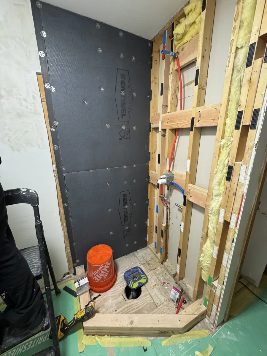 Columbus bathroom remodel, shower area with black waterproofing membrane, exposed studs, new PEX plumbing & drain. 614 Remodeling Pros.