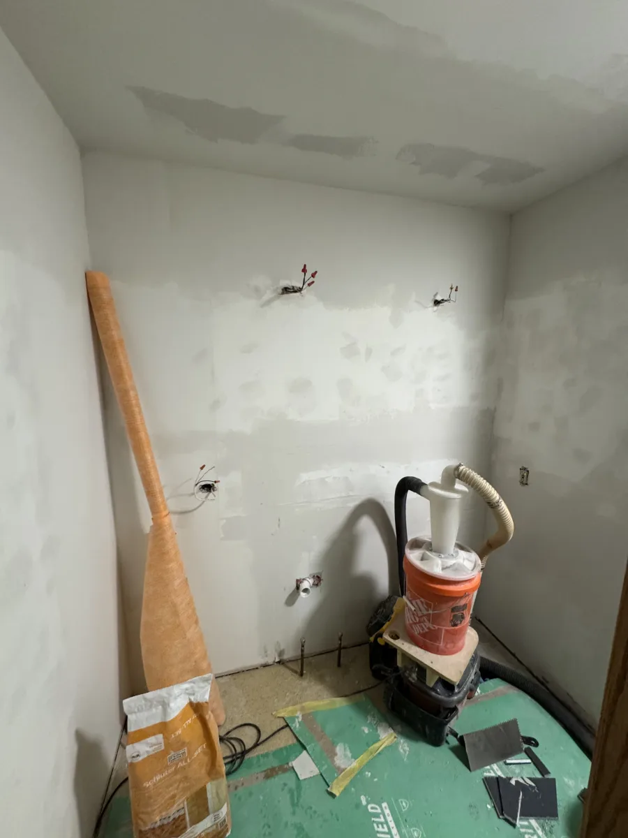 Columbus modern bathroom remodel prep with patched drywall, electrical, plumbing rough-ins, and Schluter materials ready for tiling.