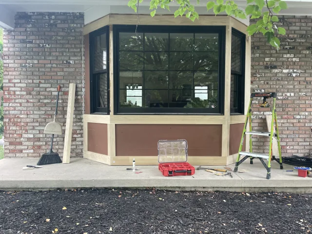 Columbus exterior bay window transformation: new black windows installed with modern wood trim by 614 Property Maintenance.